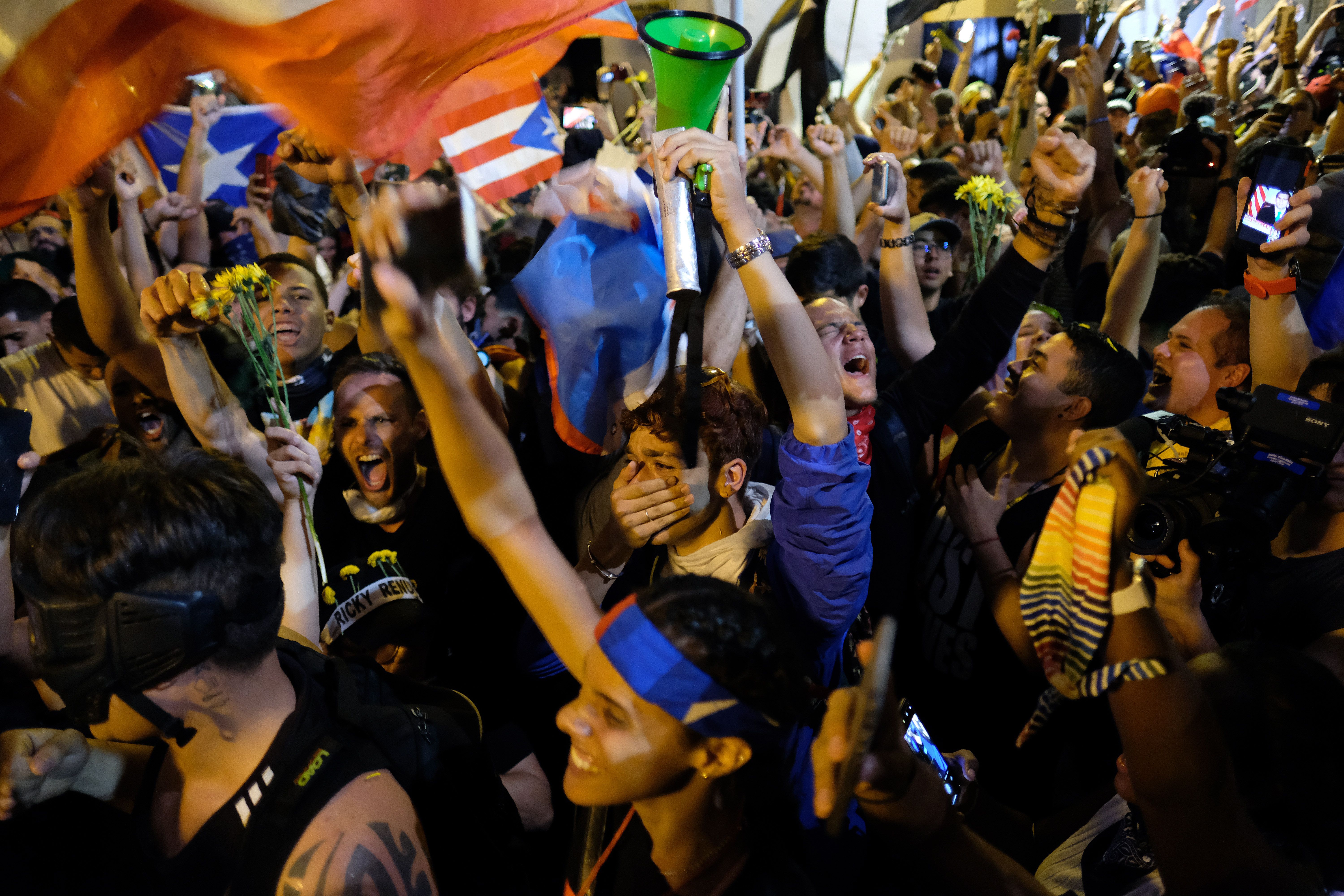 Demonstrators celebrate after the resignation message of the governor of Puerto Rico, Ricardo Rosselló, in front his mansion known as La Fortaleza in San Juan, on July 24th, 2019. Puerto Rico's embattled governor announced his resignation following two weeks of massive protests triggered by the release of a chat exchange in which he and others mocked gays, women, and hurricane victims.