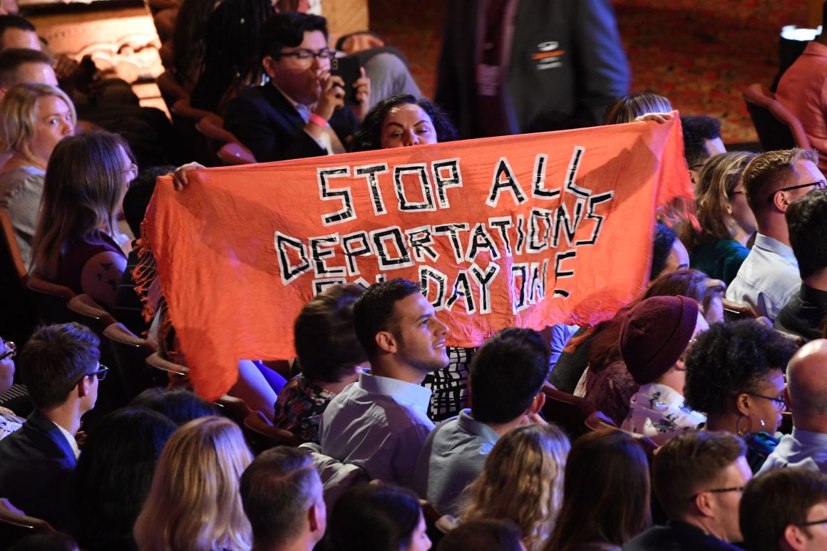 A protester unfurls a banner as Democratic presidential hopefuls participate in the second round of the second Democratic primary debate of the 2020 presidential campaign season hosted by CNN at the Fox Theatre in Detroit, Michigan, on July 31st, 2019.