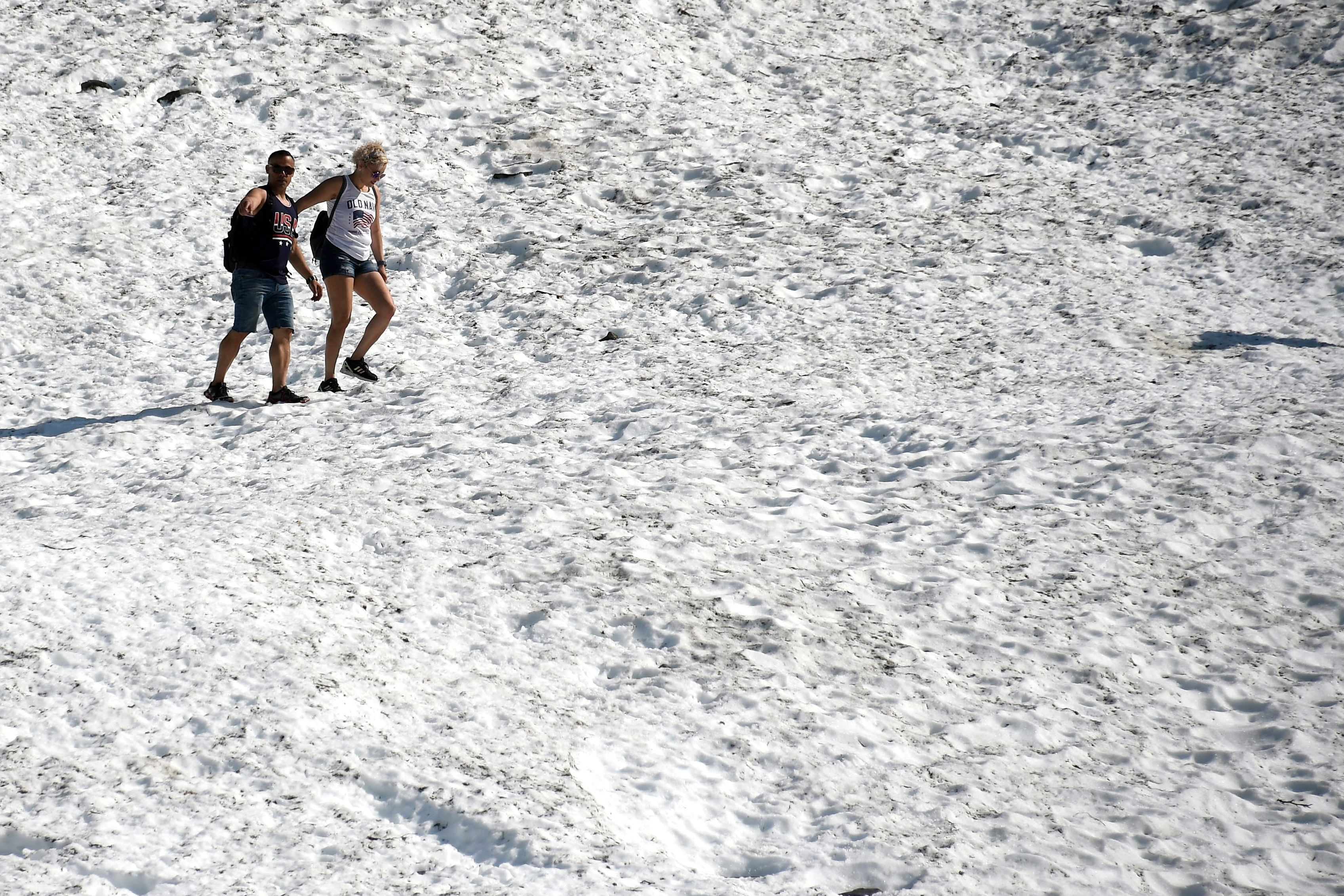 People hike on the Byron Glacier on July 4th, 2019, near Portage Lake in Girdwood, Alaska. Alaska is bracing for record warm temperatures and dry conditions in parts of the state. Anchorage hit a record high of 90 degrees Fahrenheit on July 4th.