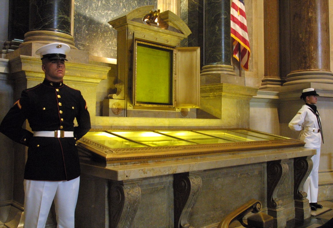 An honor guard stands next to the original copies of the Declaration of Independence, the Constitution, and the Bill of Rights on July 4th, 2001, at the National Archives in Washington, D.C.