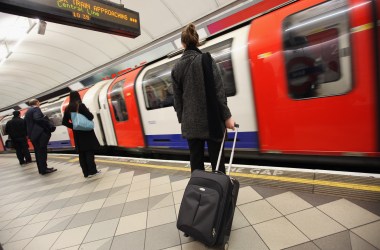 Commuters wait for a train at a London Underground station.