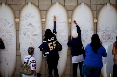 Friends, family members, and supporters sign surfboards as they pay tribute to former NFL star Junior Seau during a public memorial at Qualcomm Stadium on May 11th, 2012, in San Diego, California.