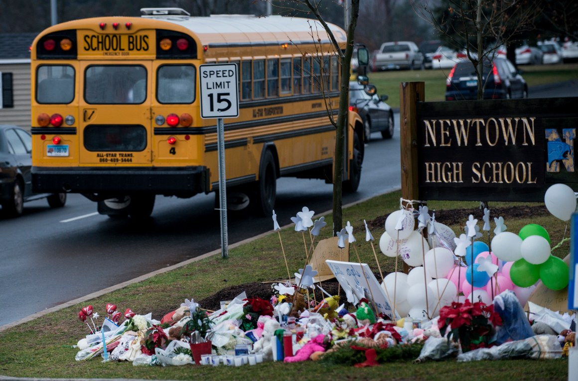 A school bus passes a memorial to the victims of the Sandy Hook Elementary School shooting in Newtown, Connecticut, on December 18th, 2012.