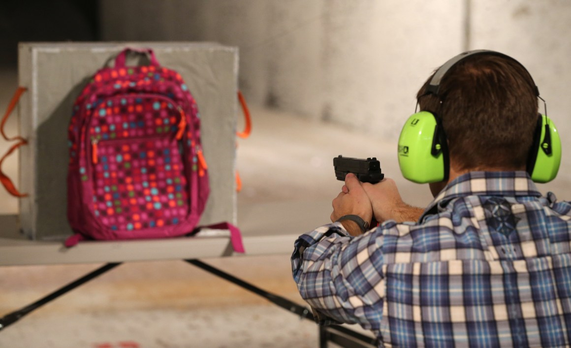 Chief operating officer for Amendment II, Rich Brand, shoots a child's backpack with the company's bulletproof shield inserted in it in December of 2012.