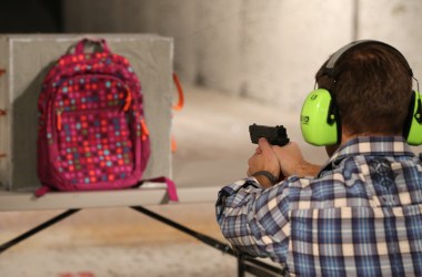 Chief operating officer for Amendment II, Rich Brand, shoots a child's backpack with the company's bulletproof shield inserted in it in December of 2012.