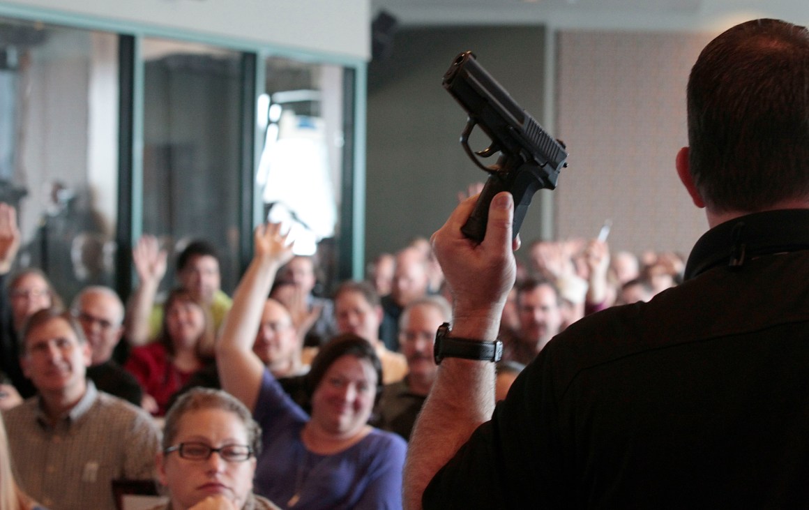 Firearm instructor Clark Aposhian holds a handgun up as he teaches a concealed-weapons training class to 200 Utah teachers in December of 2012. After the Marjory Stoneman Douglas High School shooting in Parkland, Florida, 14 state legislatures introduced bills calling to arm school staffs.