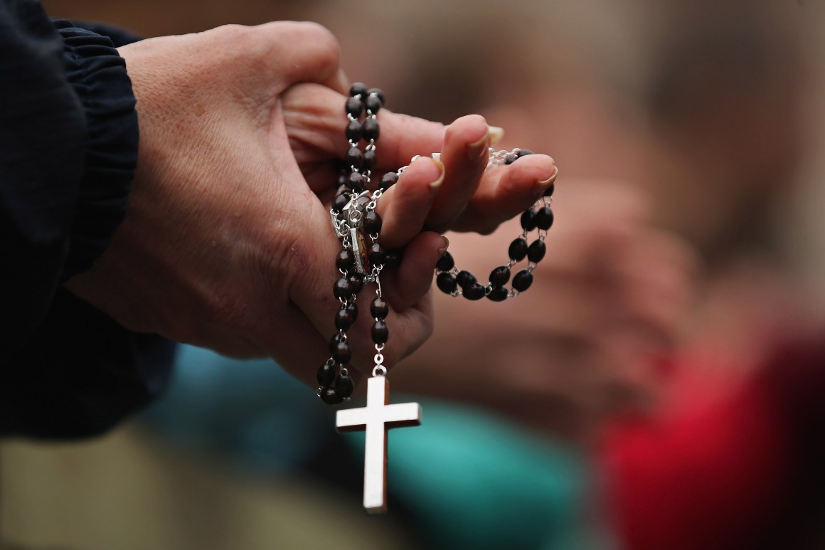 A woman holds rosary beads in Vatican City, Vatican.