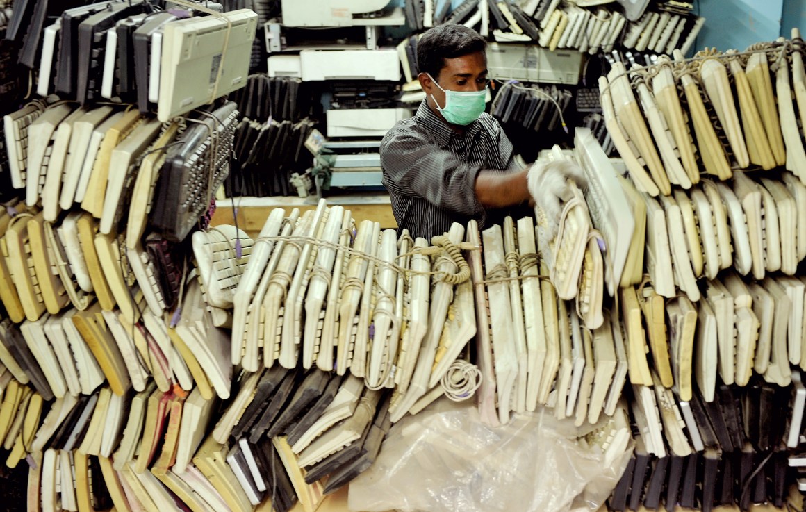 Man stores stacks of computer keyboards.