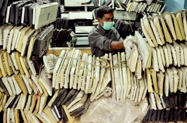 Man stores stacks of computer keyboards.