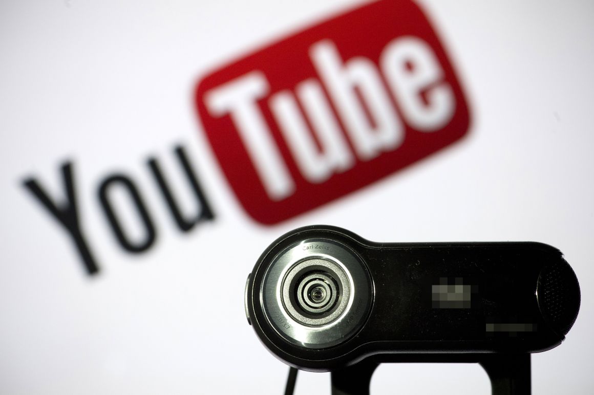 A webcam is pictured in front of the YouTube logo.