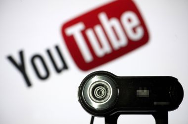 A webcam is pictured in front of the YouTube logo.