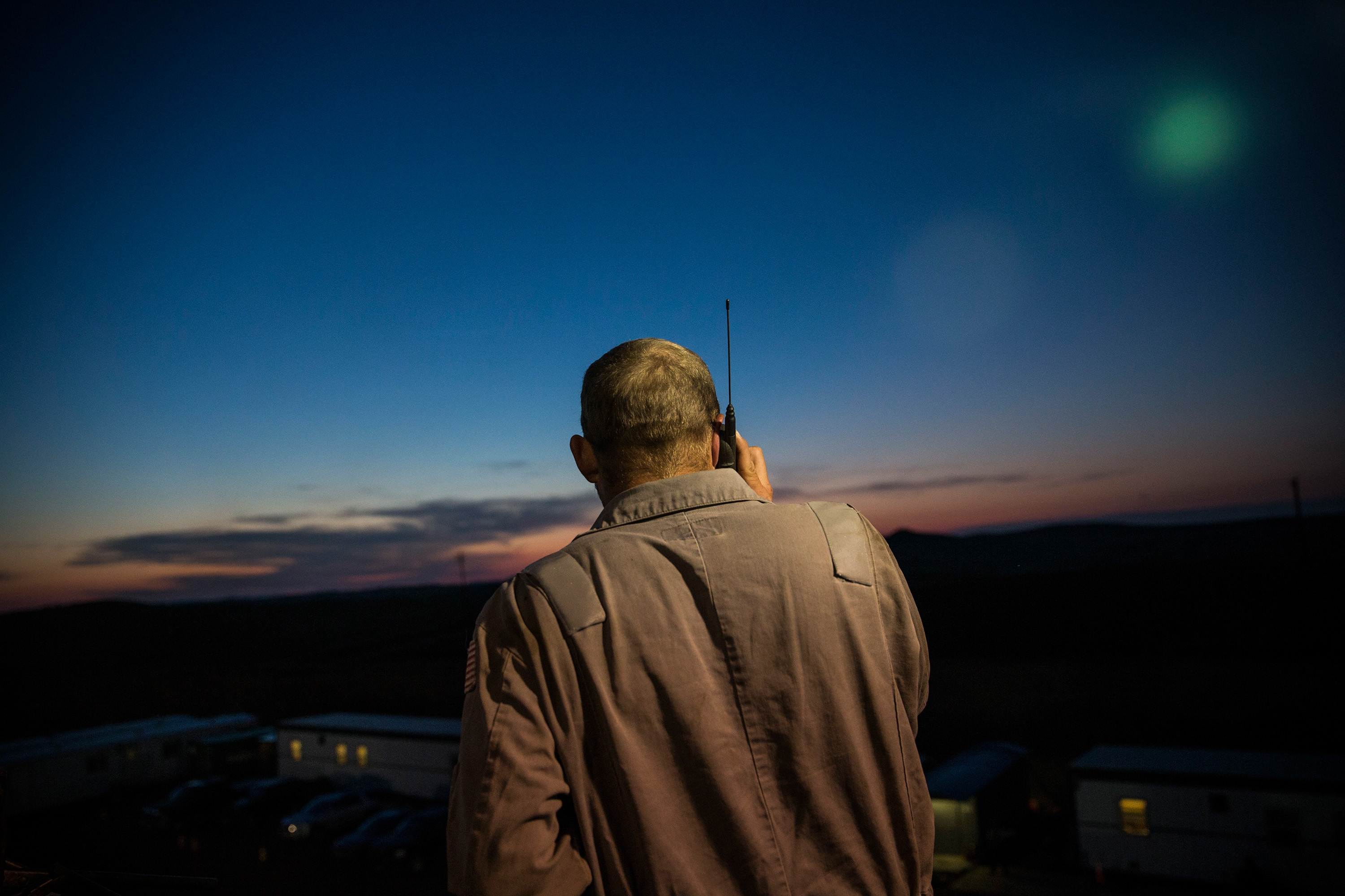 Phillip Chambers, a driller for Raven Drilling, talks on a phone while drilling for oil in the Bakken shale formation on July 23rd, 2013, outside Watford City, North Dakota.