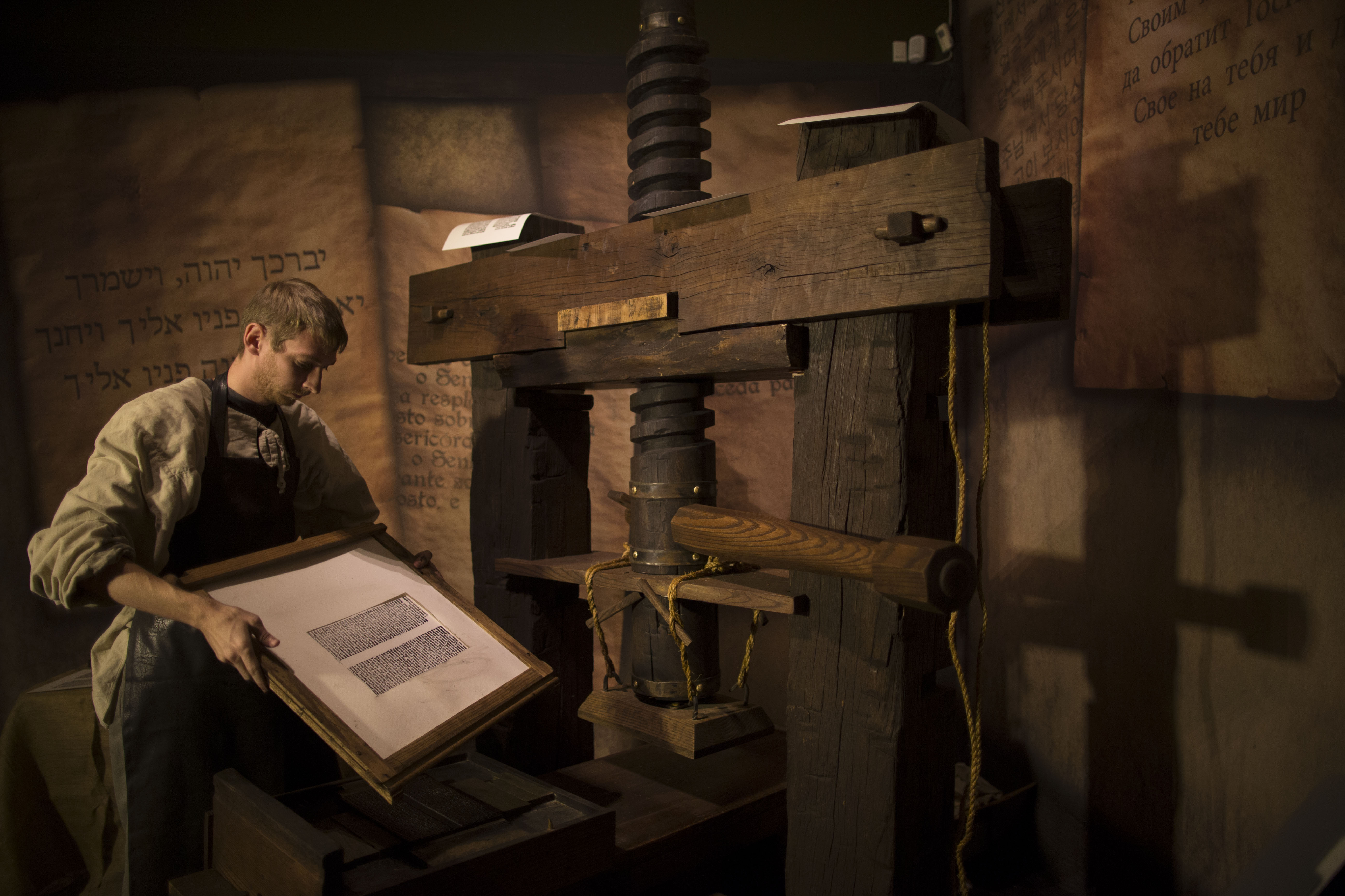 A museum employee shows how a Johannes Gutenberg replica printing press is used at the Book of Books exhibition in the Bible Lands Museum on October 23rd, 2013, in Jerusalem, Israel.