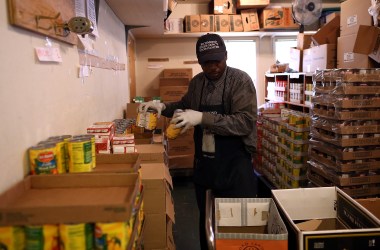 Richmond Emergency Food Bank volunteer Abdul Olorode packs boxes with food to be handed out to needy people on November 1st, 2013, in Richmond, California.