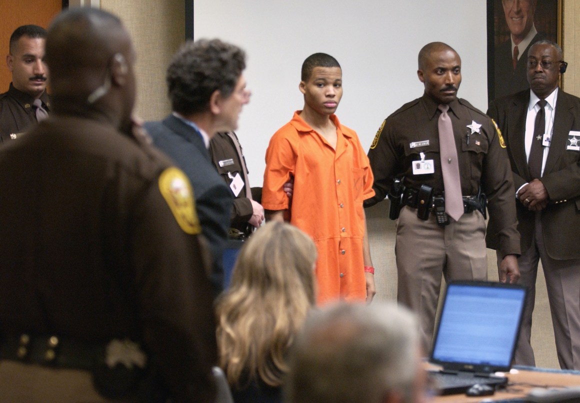 Sniper suspect Lee Boyd Malvo (center) is escorted by deputies as he is brought into court to be identified by a witness during the murder trial in courtroom 10 at the Virginia Beach Circuit Court on October 22nd, 2003, in Virginia Beach, Virginia.