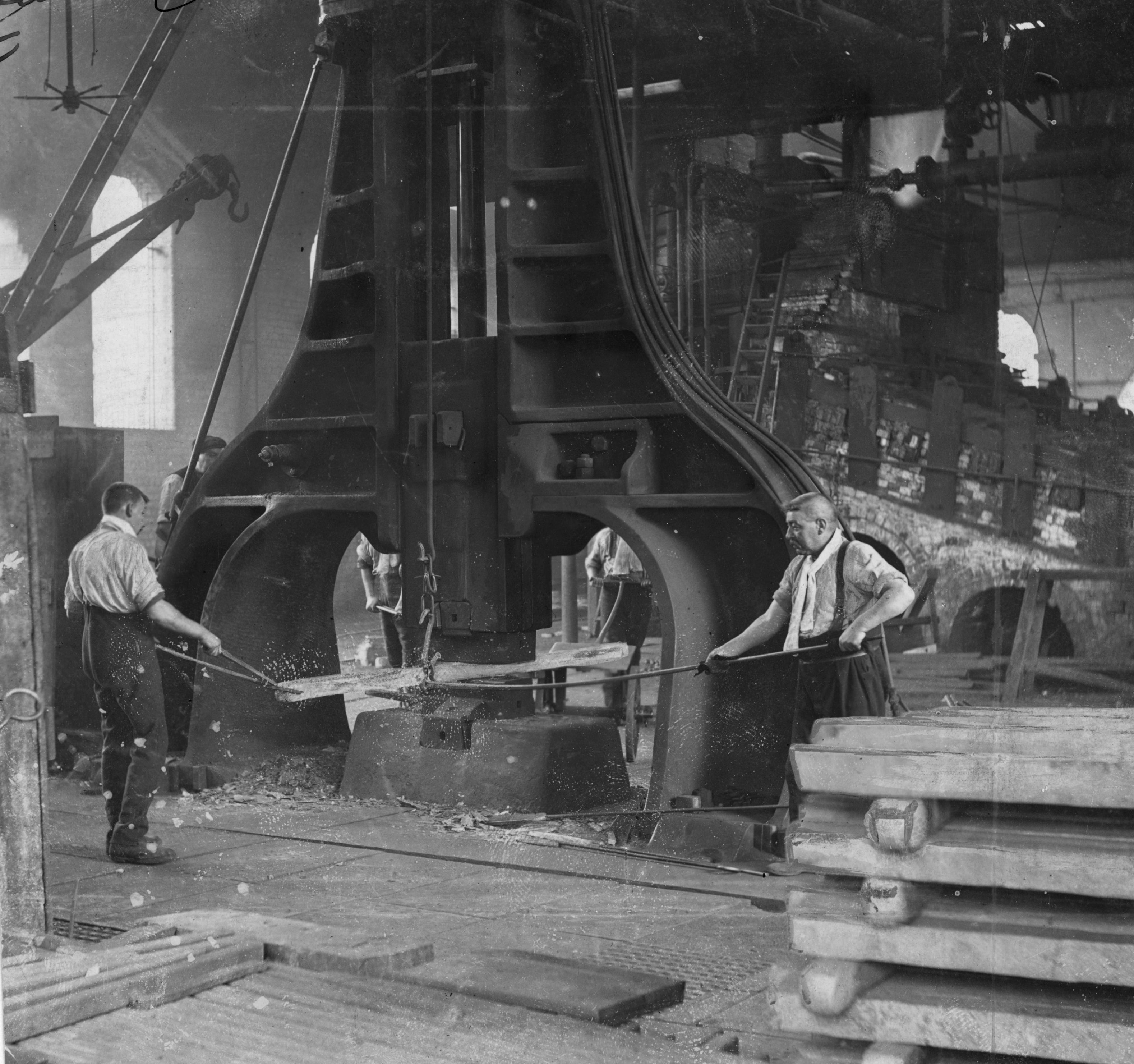 Steel workers in Pittsburgh, Pennsylvania, where the Bessemer Converter was in use manhandling a piece of hot steel.