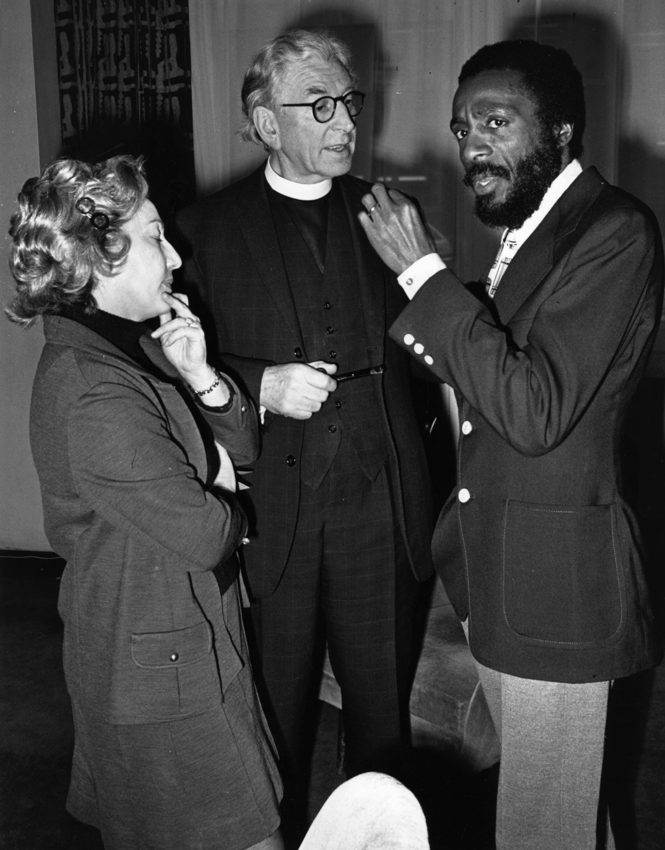 Dick Gregory talks to Canon Collins (center) at St. Paul's Cathedral the week before giving a show during a special celebration for the International Year Against Racial Discrimination in December of 1971.