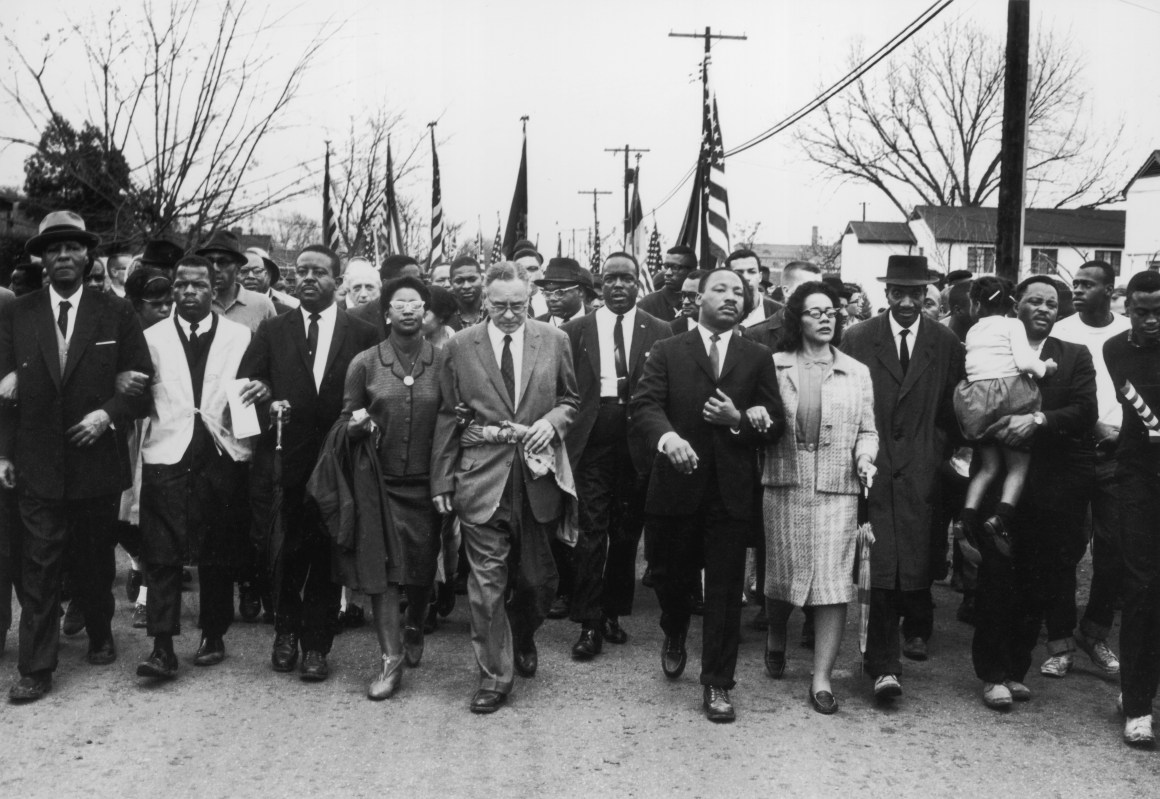 Martin Luther King and Coretta Scott King lead a civil rights march in Selma, Alabama.