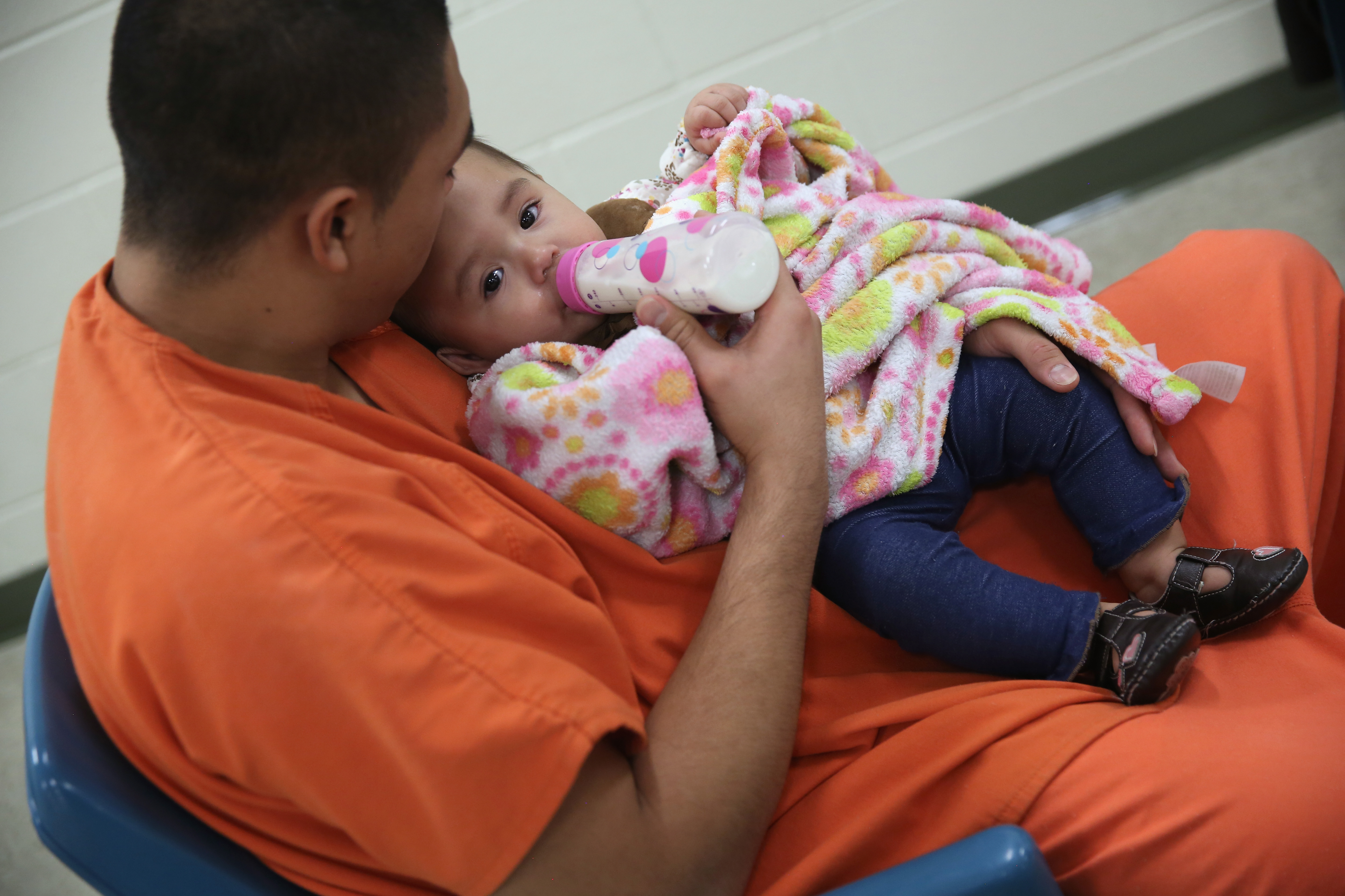 An immigrant feeds his daughter during a family visitation at the Adelanto Detention Facility, in San Bernardino County, California.