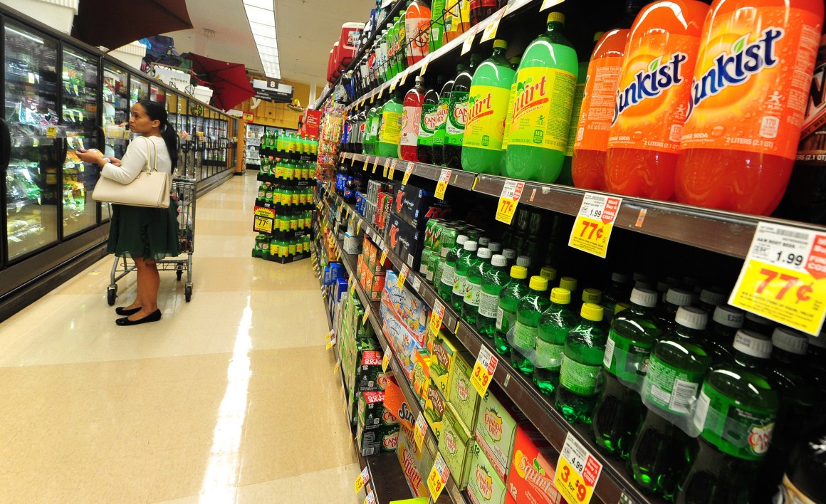 A woman shops for frozen foods on an aisle across from sodas and other sugary drinks for sale at a supermarket in Monterey Park, California.