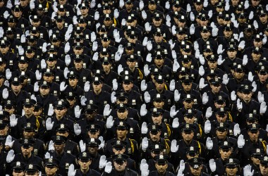 The 2014 class of the New York Police Department raise their hands while taking an oath on June 30th, 2014, at Madison Square Garden in New York City.