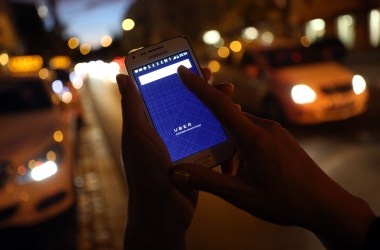 A woman uses the Uber app on her mobile phone.