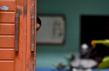 A migrant child watches behind the main door of a shelter in Tapachula, Mexico, where he's taken a rest during his attempt to reach the border between Mexico and the United States.