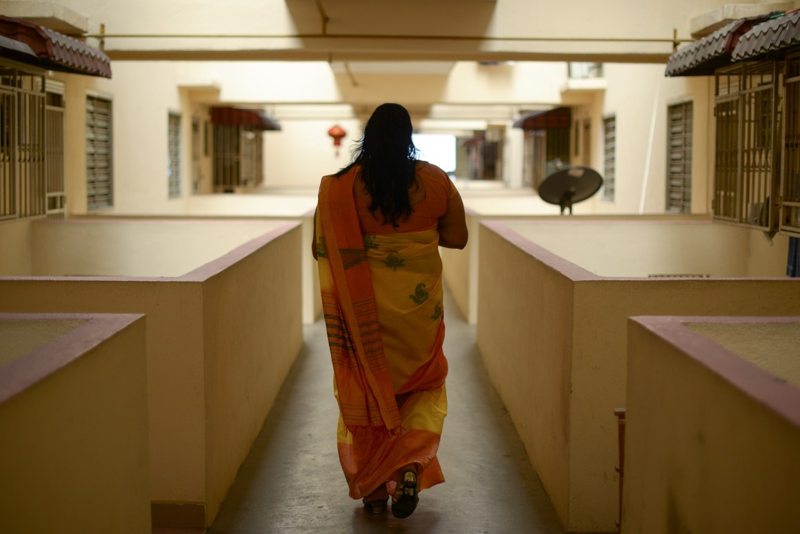 A trans Malaysian woman walks down an apartment corridor in Kuala Lumpur on September 23rd, 2014.