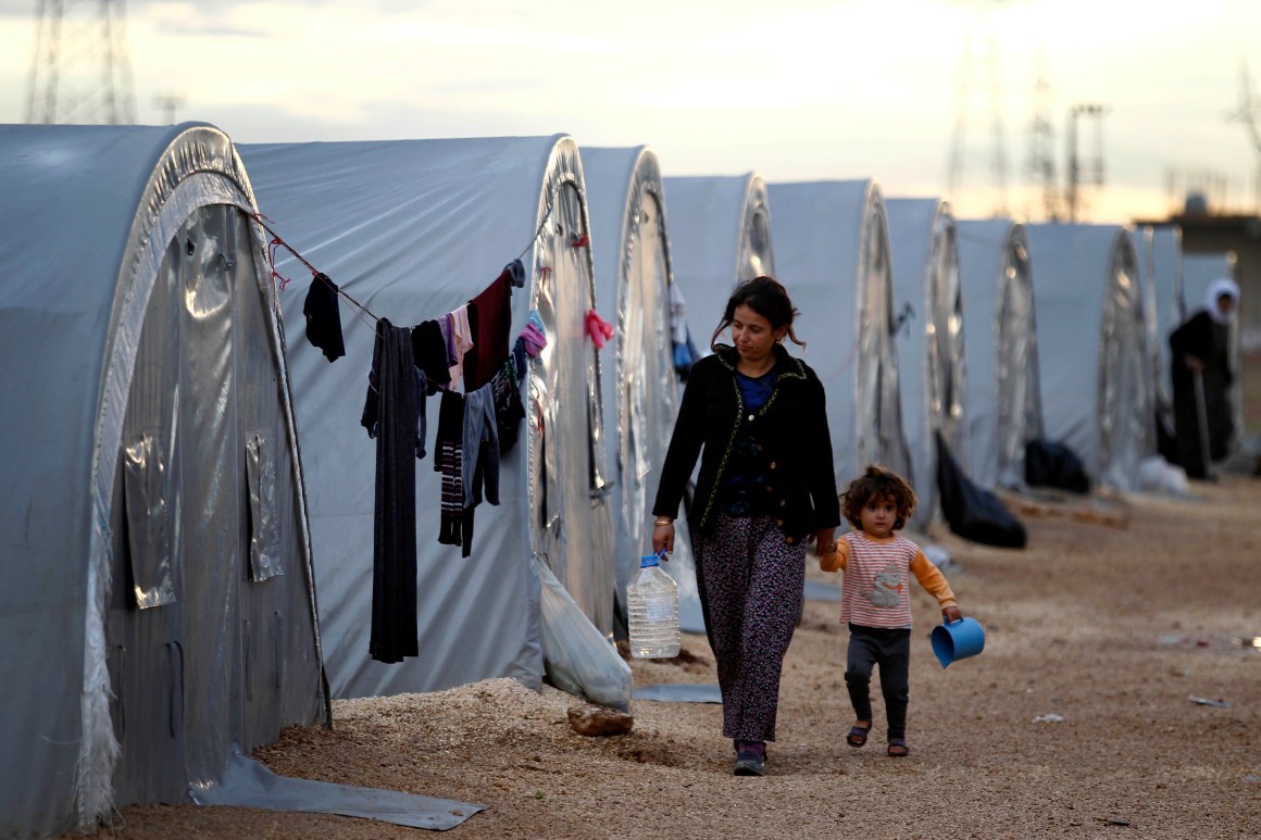 Kurdish refugees from the Syrian town of Kobani walk besides their tents in a camp in the southeastern town of Suruc on the Turkish-Syrian border.