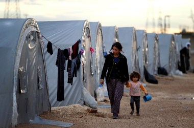 Kurdish refugees from the Syrian town of Kobani walk besides their tents in a camp in the southeastern town of Suruc on the Turkish-Syrian border.