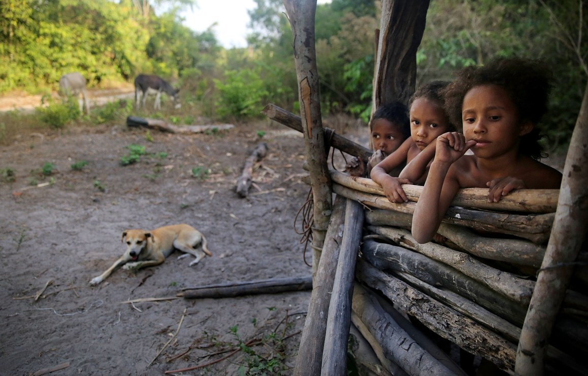 Young members of the Serra family gather in the building where family members make traditional farinha near their home in the Imbiral quilombo, which community members say is being heavily encroached upon by illegal logging and cattle ranching.