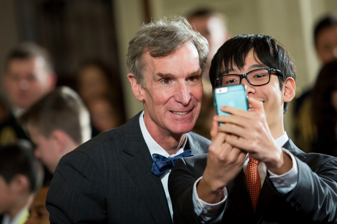 Scientist Bill Nye takes a selfie photo with a student.