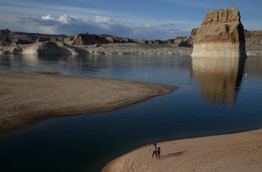 People walk on a beach that used to be the bottom of Lake Powell on March 29th, 2015, near Big Water, Utah. Lake Powell is one of the Colorado River Basin's two biggest reservoirs, along with Lake Mead.