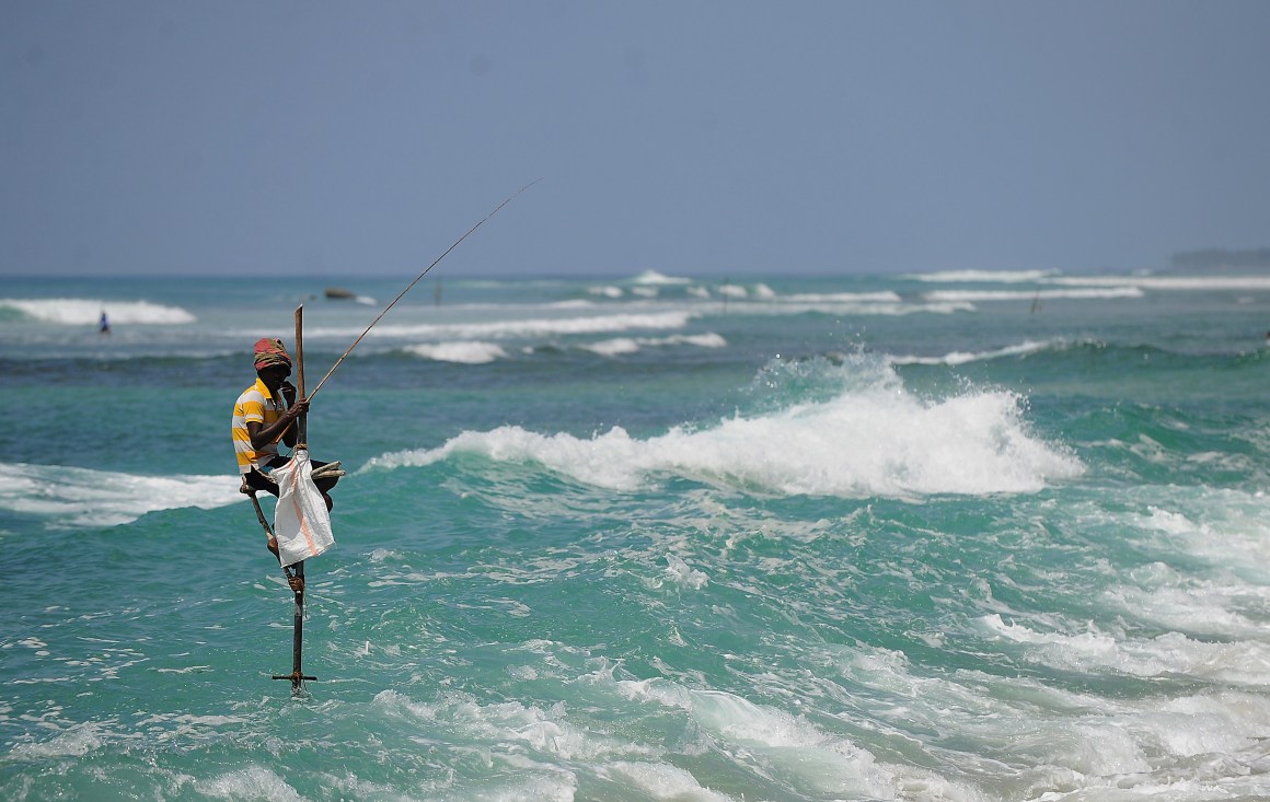 A Sri Lankan stilt fisherman works on his pole in the southern town of Galle.