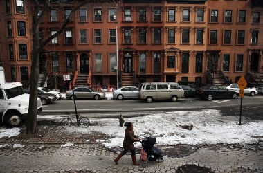 A woman and child walk down a street in the Fort Greene neighborhood where the director and artist Spike Lee once lived on February 27th, 2014, in the Brooklyn borough of New York City.