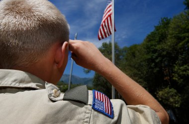 A Boy Scout salutes the American flag at on July 31st, 2015, outside Payson, Utah.