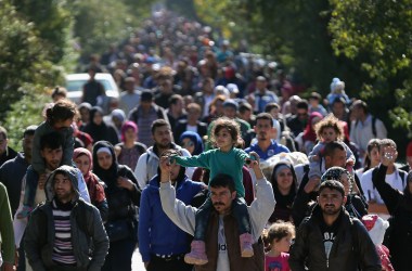 Hundreds of migrants who arrived by train at Hegyeshalom on the Hungarian and Austrian border walk the four kilometers into Austria on September 22nd, 2015, in Hegyeshalom, Hungary.