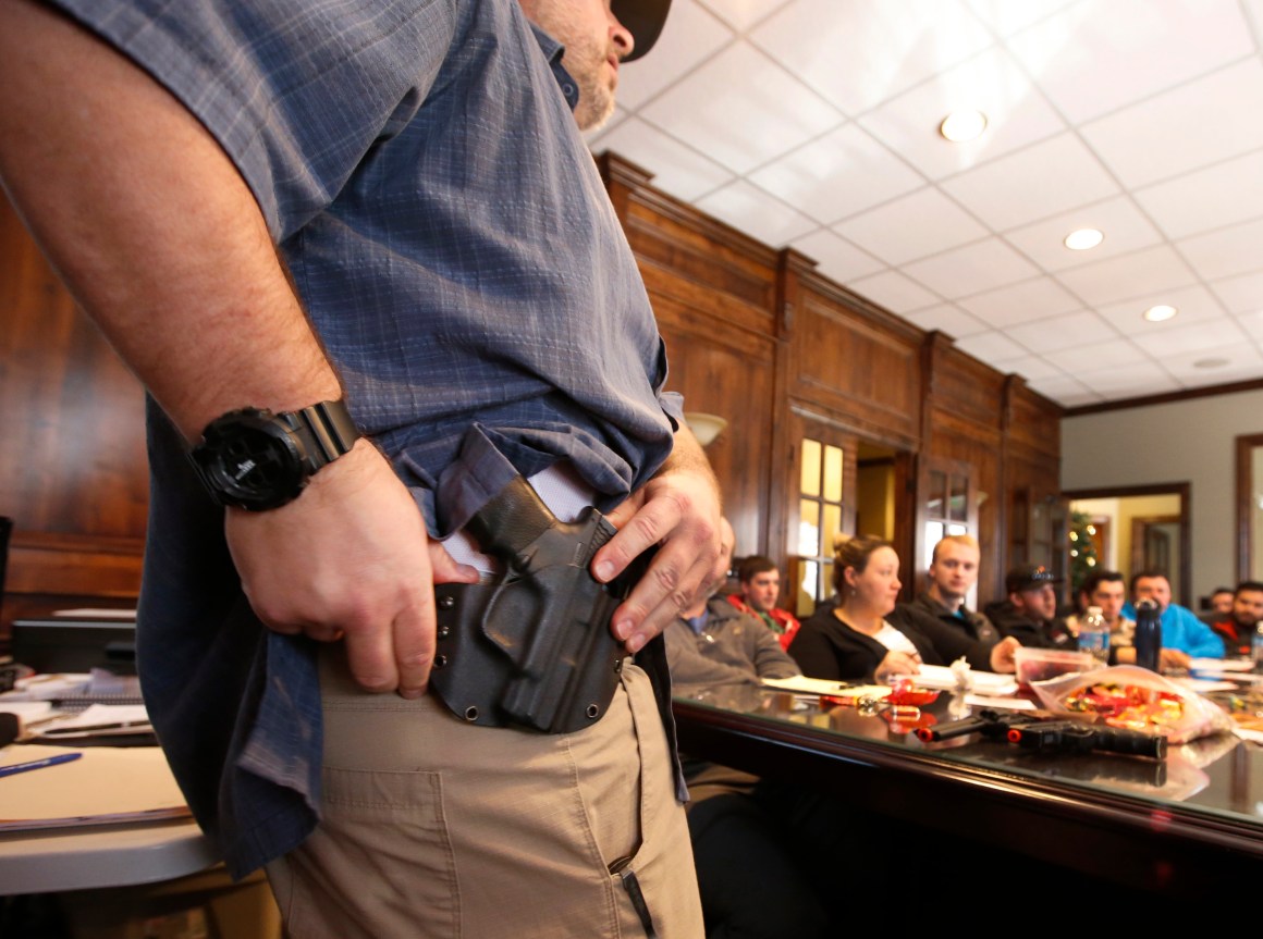 A man shows a holster at a concealed-carry permit class put on by USA Firearms Training on December 19th, 2015, in Provo, Utah.