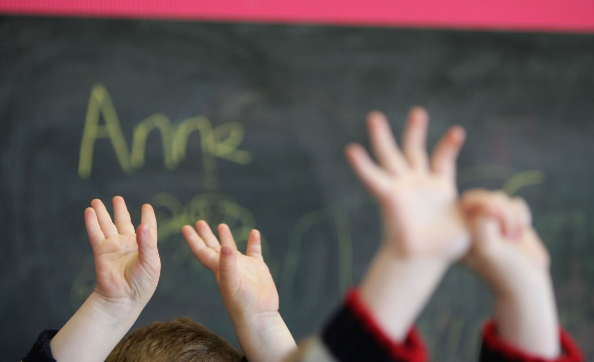 Children wave their hands at a private nursery school in Glasgow, Scotland.