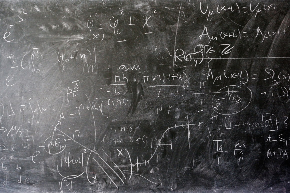 A detailed view of the blackboard with theoretical physics equations in chalk by Alberto Ramos.