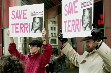 John Jansen and Joseph Scheidler carry signs calling for continued care and feeding of Terry Schiavo during a protest at the Thompson Center Plaza on March 29th, 2005, in Chicago, Illinois.