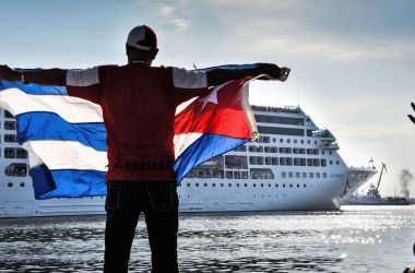 A man waves a Cuban flag at the Malecon waterfront as the first U.S.-to-Cuba cruise ship to arrive in the island nation in decades glides into the port of Havana, on May 2nd, 2016.