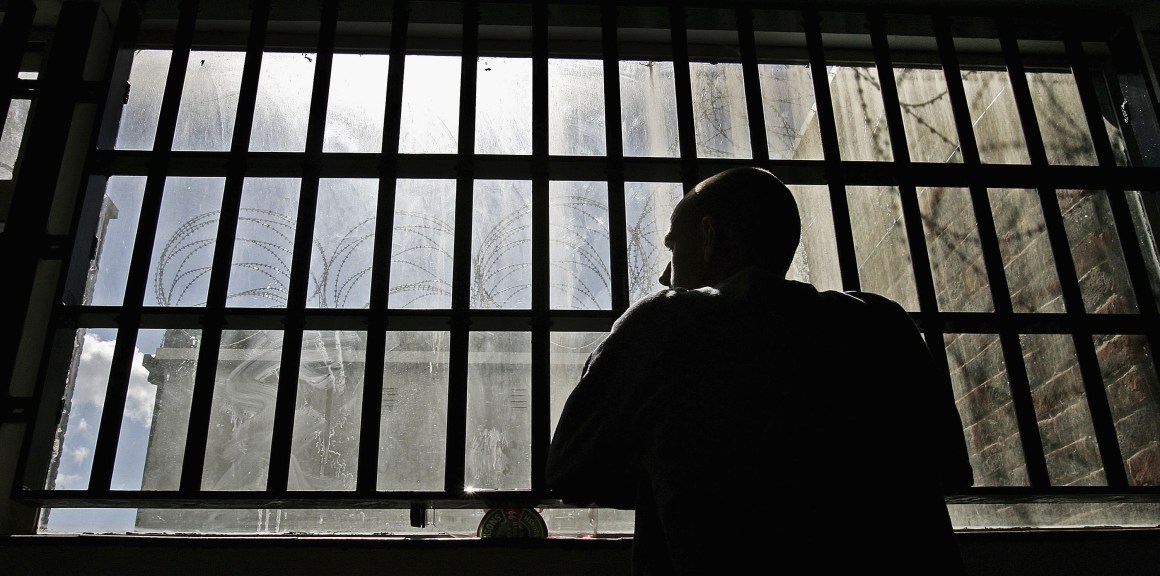 An inmate looks out of the window of the Young Offenders Institution in Norwich, England.