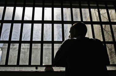 An inmate looks out of the window of the Young Offenders Institution in Norwich, England.