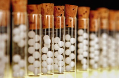 Vials containing pills for homeopathic remedies are displayed at a pharmacy.