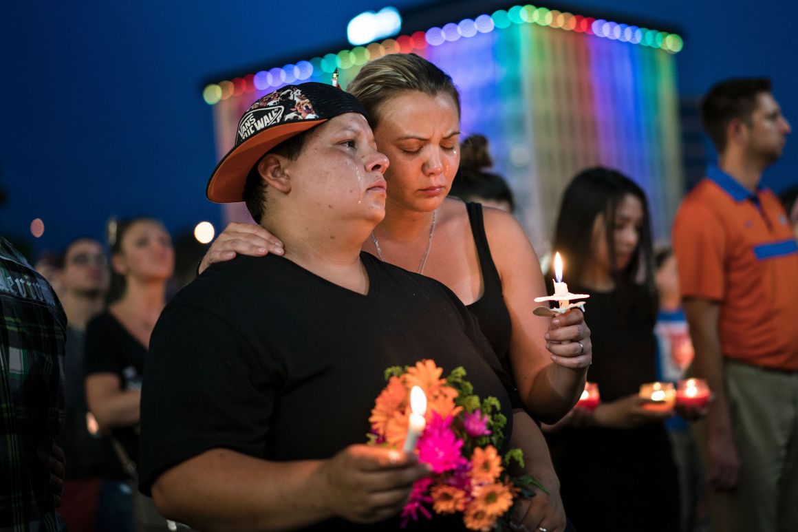 Nicole Edwards and her wife Kellie Edwards observe a moment of silence during a vigil outside the Dr. Phillips Center for the Performing Arts for the mass shooting victims at the Pulse nightclub June 13, 2016 in Orlando, Florida.