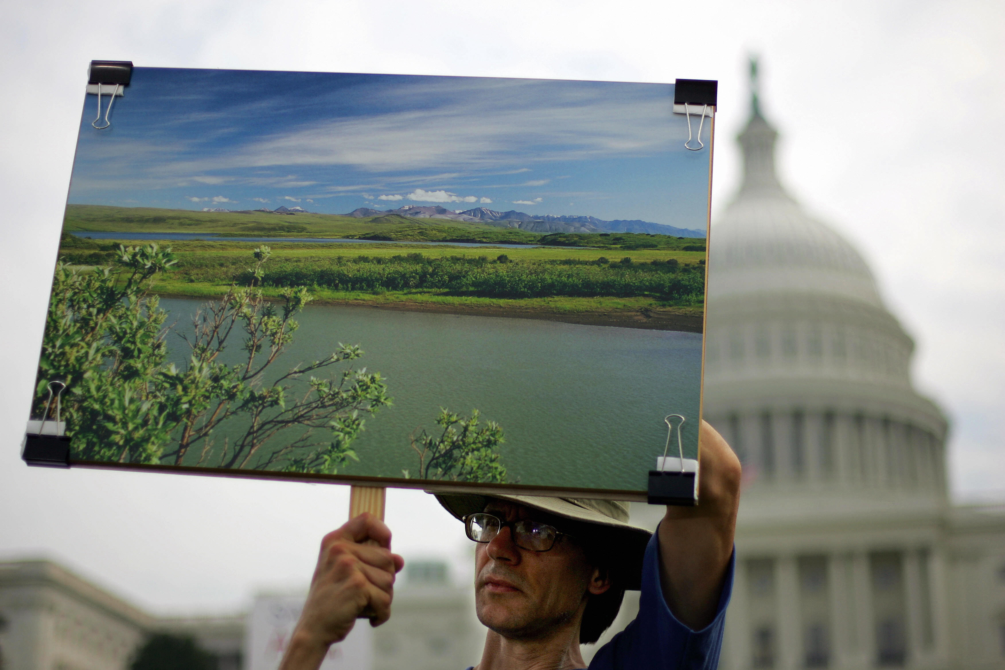 Thomas Joswiak holds a photograph of the Arctic National Wildlife Refuge at a large rally on the West Lawn of the Capitol.