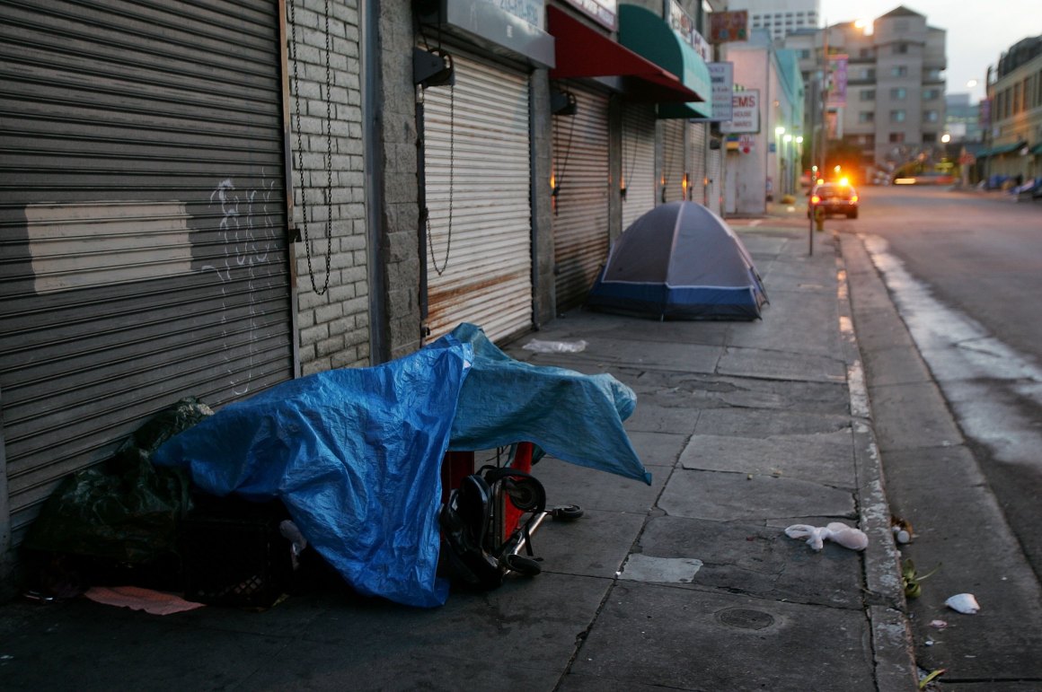 A police car stops near a homeless encampment on April 19th, 2006, in Los Angeles, California.