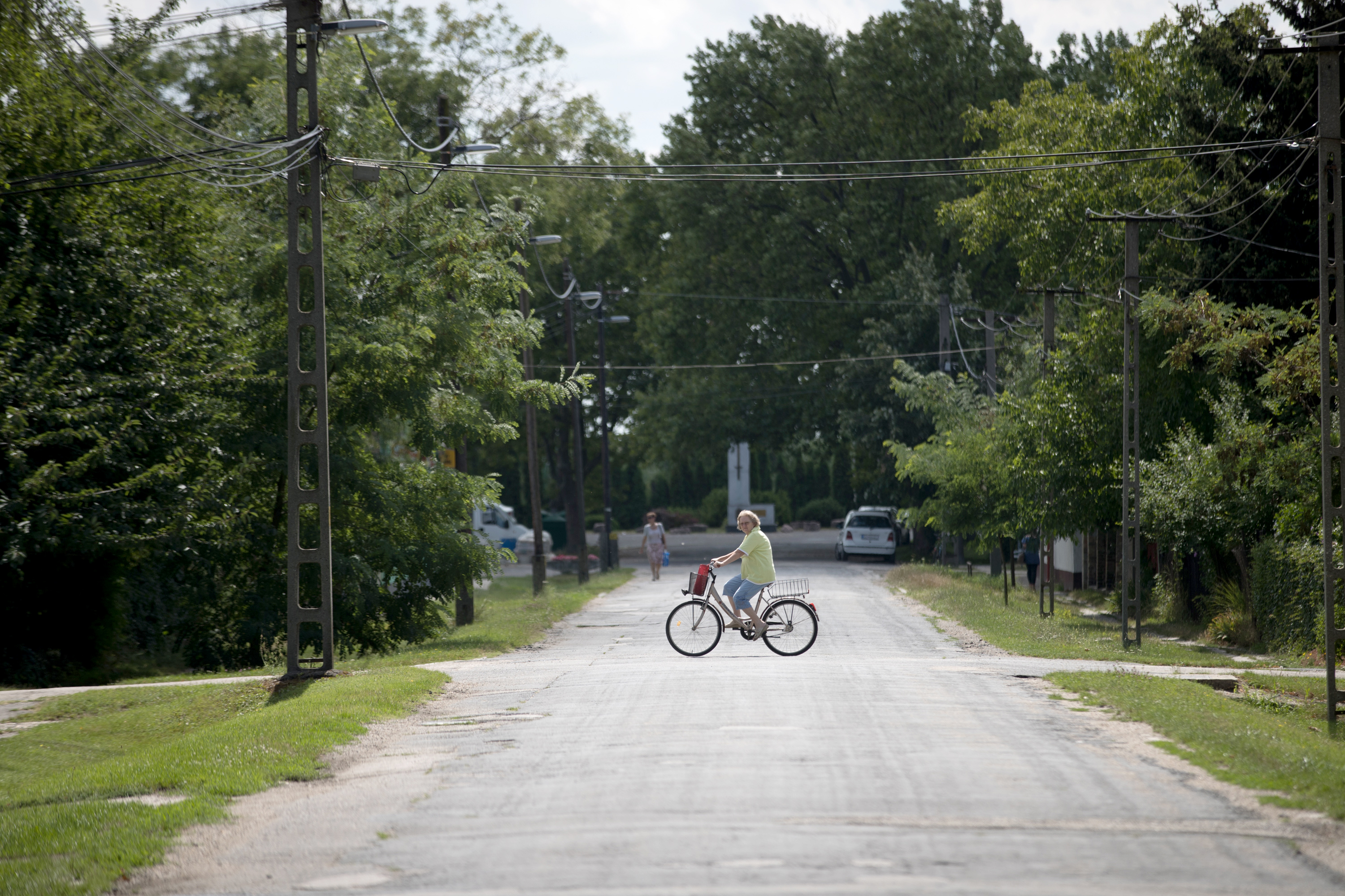 A woman rides her bike along an empty road close to the railway station in Hegyeshalom, Hungary.