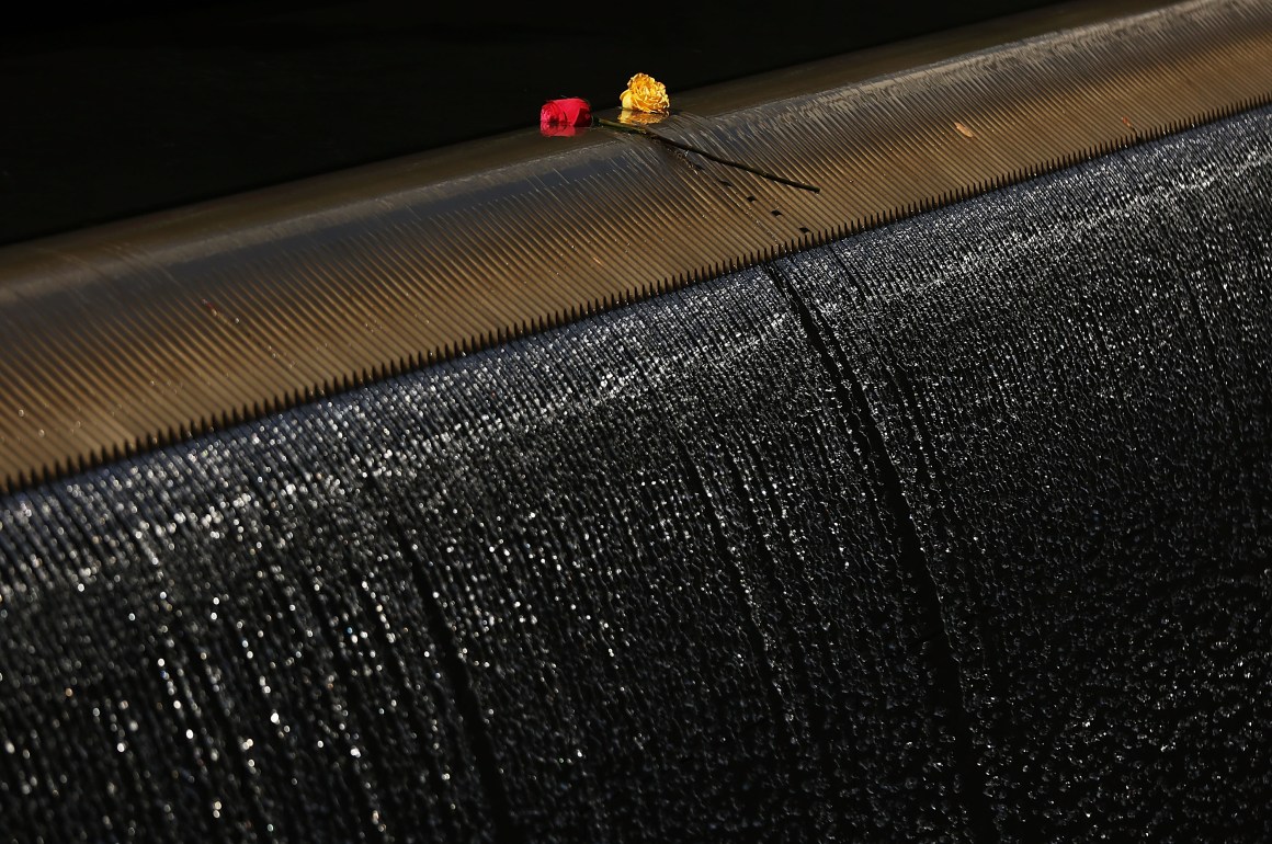 Two roses sit on the edge of one of the reflecting pools at the September 11th Memorial following a commemoration ceremony for the victims of the terrorist attacks on September 11th, 2016, in New York City.